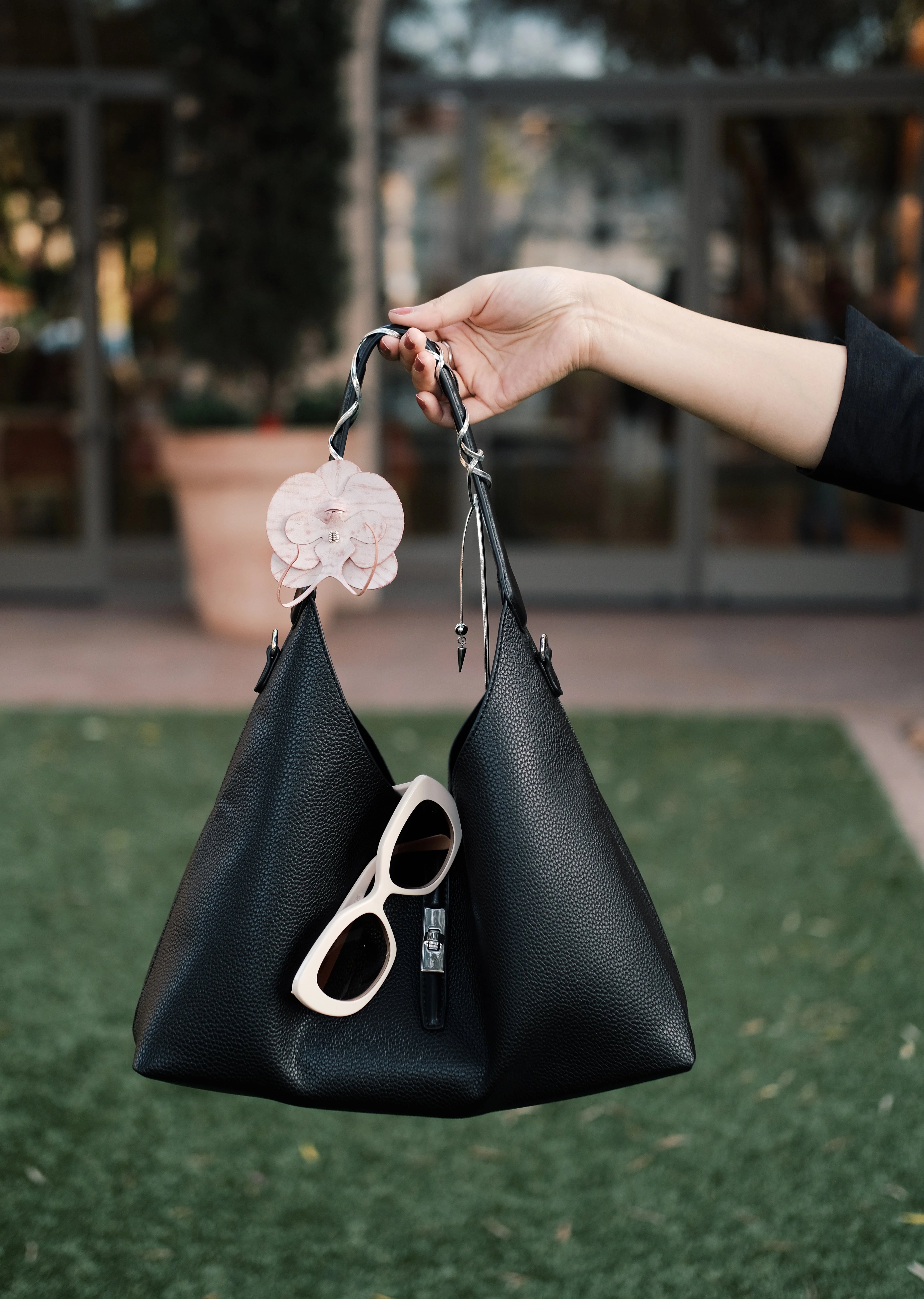 Black tote bag with sunglasses placed on top