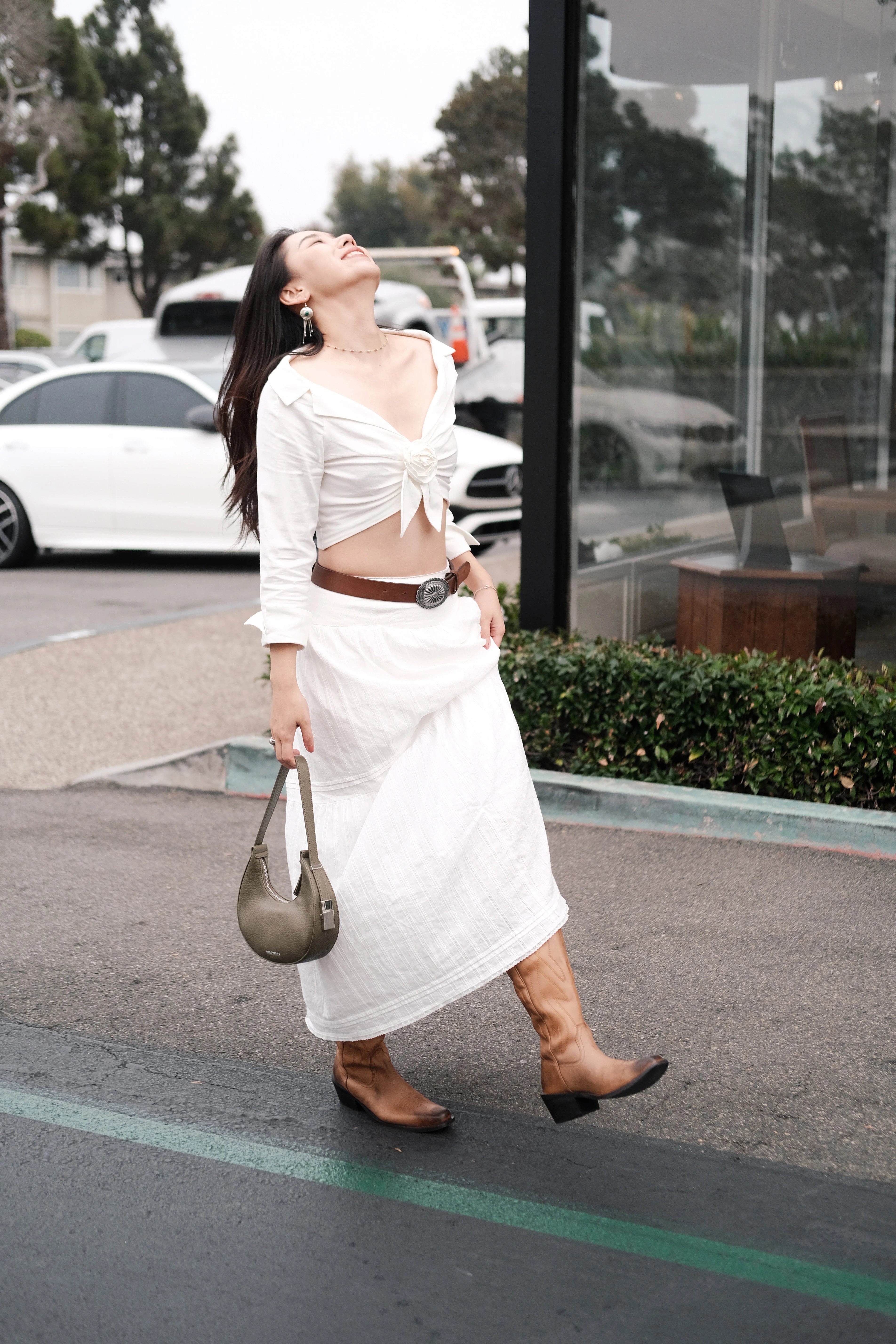 Girl wearing a white dress holding a green mini shoulder bag